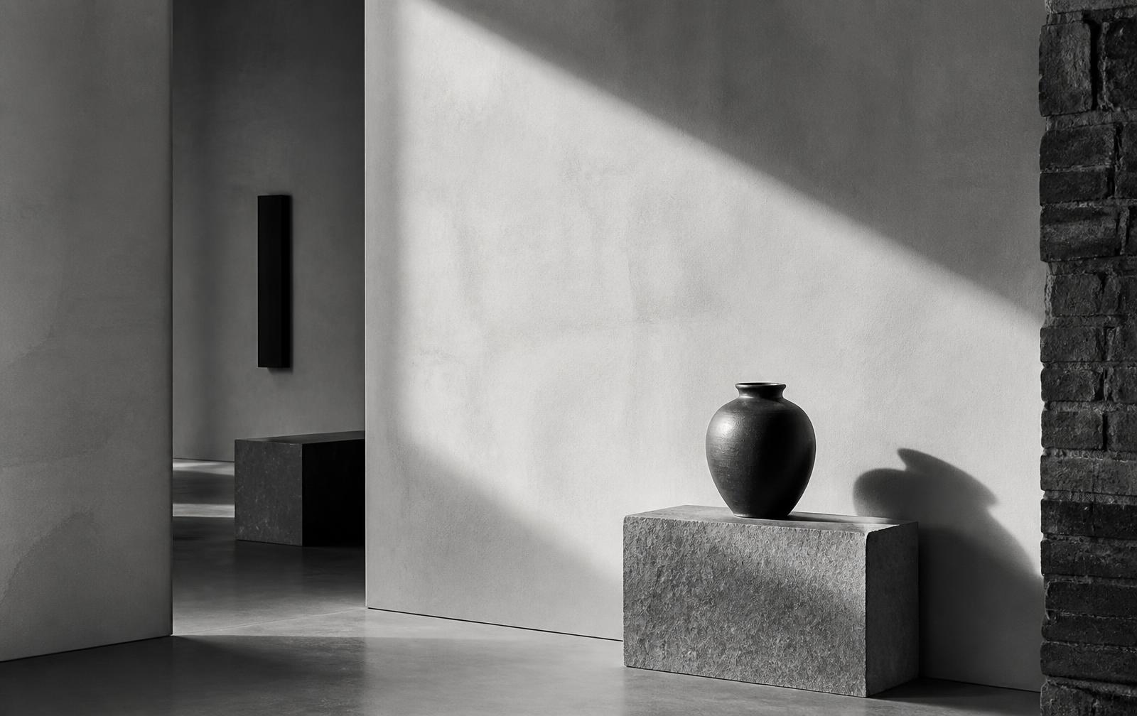 Monochrome interior study: stone plinth and single vessel